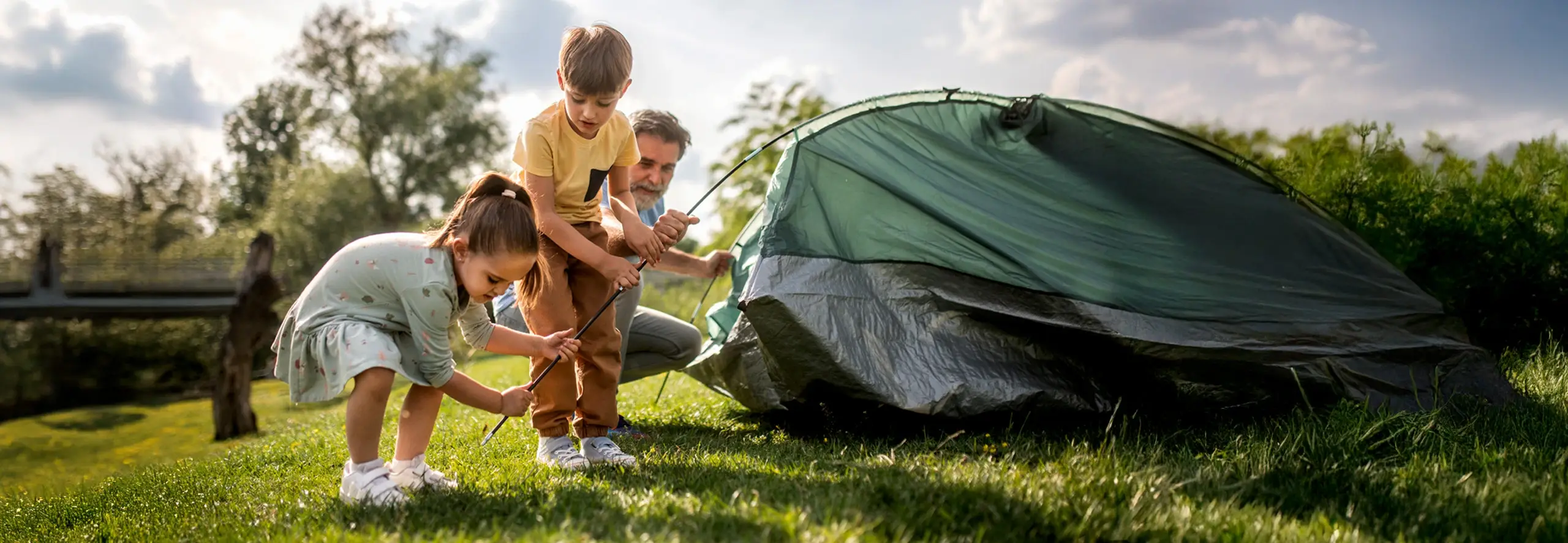 Crianças a montar um acampamento para umas férias económicas em família.
