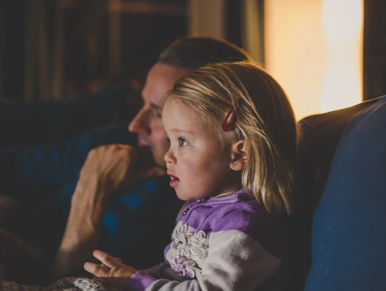 pai e filha surpreendida numa noite de filme.