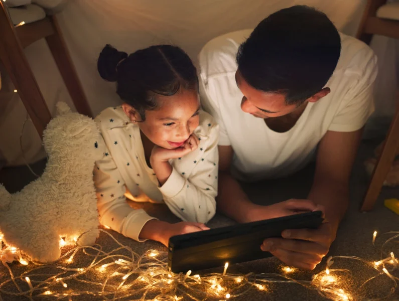 Pai a controlar uso do tablet pela filha menor de idade.