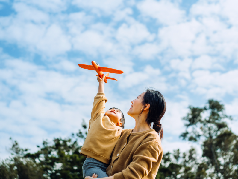 mãe e criança a divertirem-se com um avião