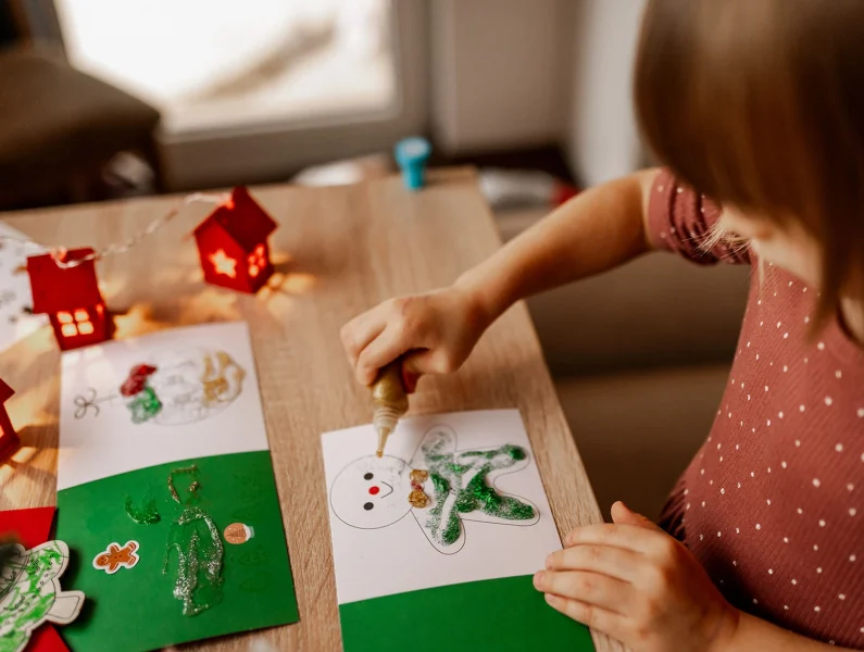 Menina a desenhar numa oficina de Natal.
