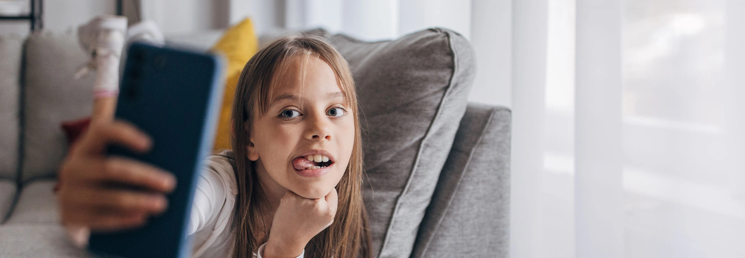 Jovem menina faz pausa nos trabalhos de casa para tirar uma selfie com o smartphone, combinando momentos de lazer digital com estudo.