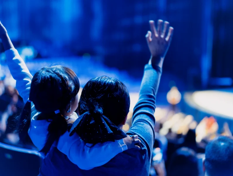 Criança e mãe a assistir a um concerto de música ao vivo.