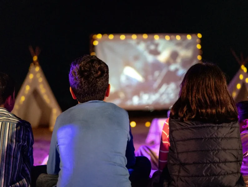 Crianças sentadas a assistir a um espetáculo infantil.
