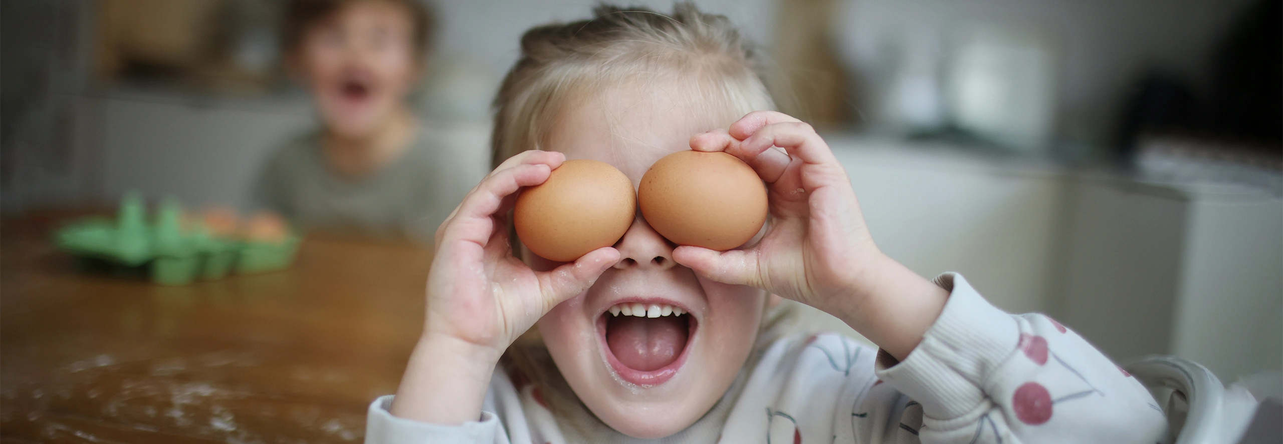 menina a esconder olhos atrás de dois ovos