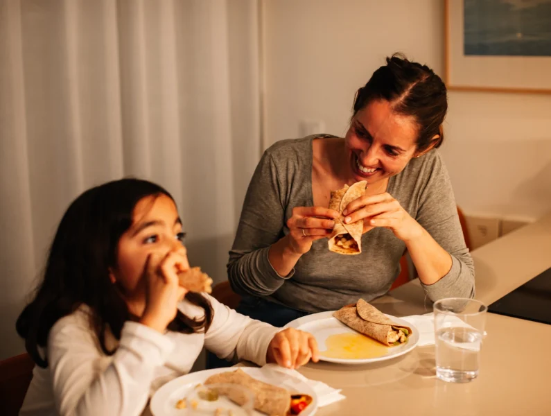 Mãe e filha a comer um wrap saudável