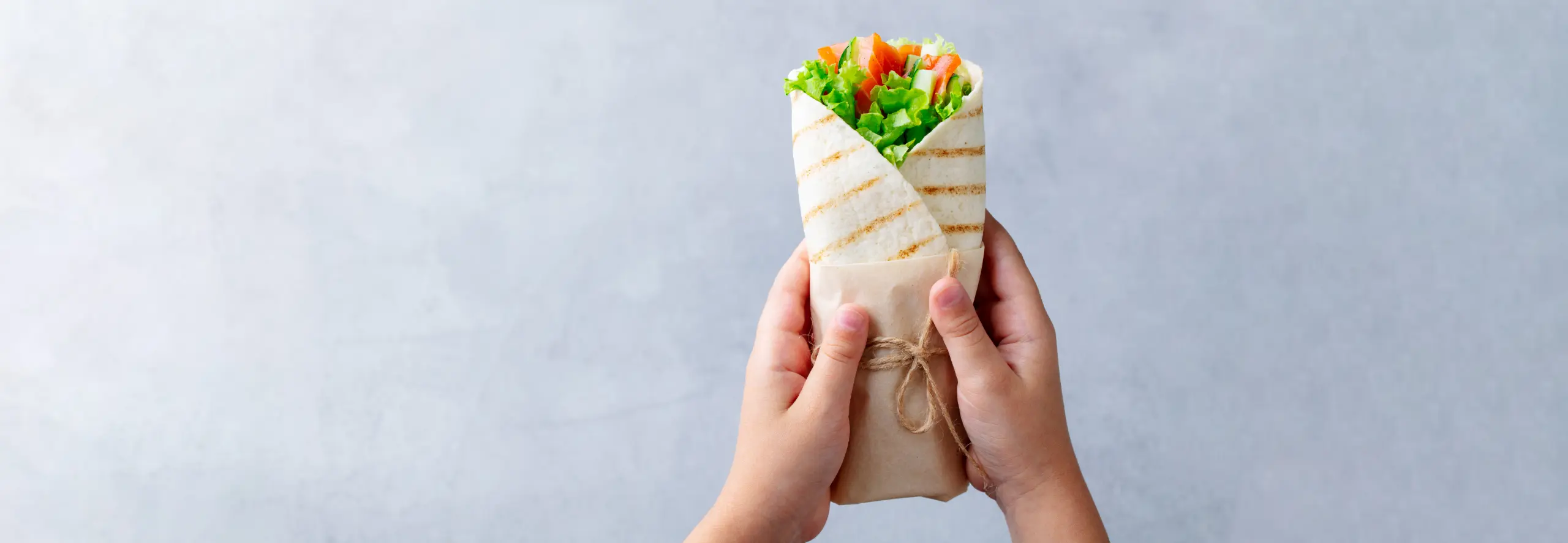 Criança a segurar um wrap saudável